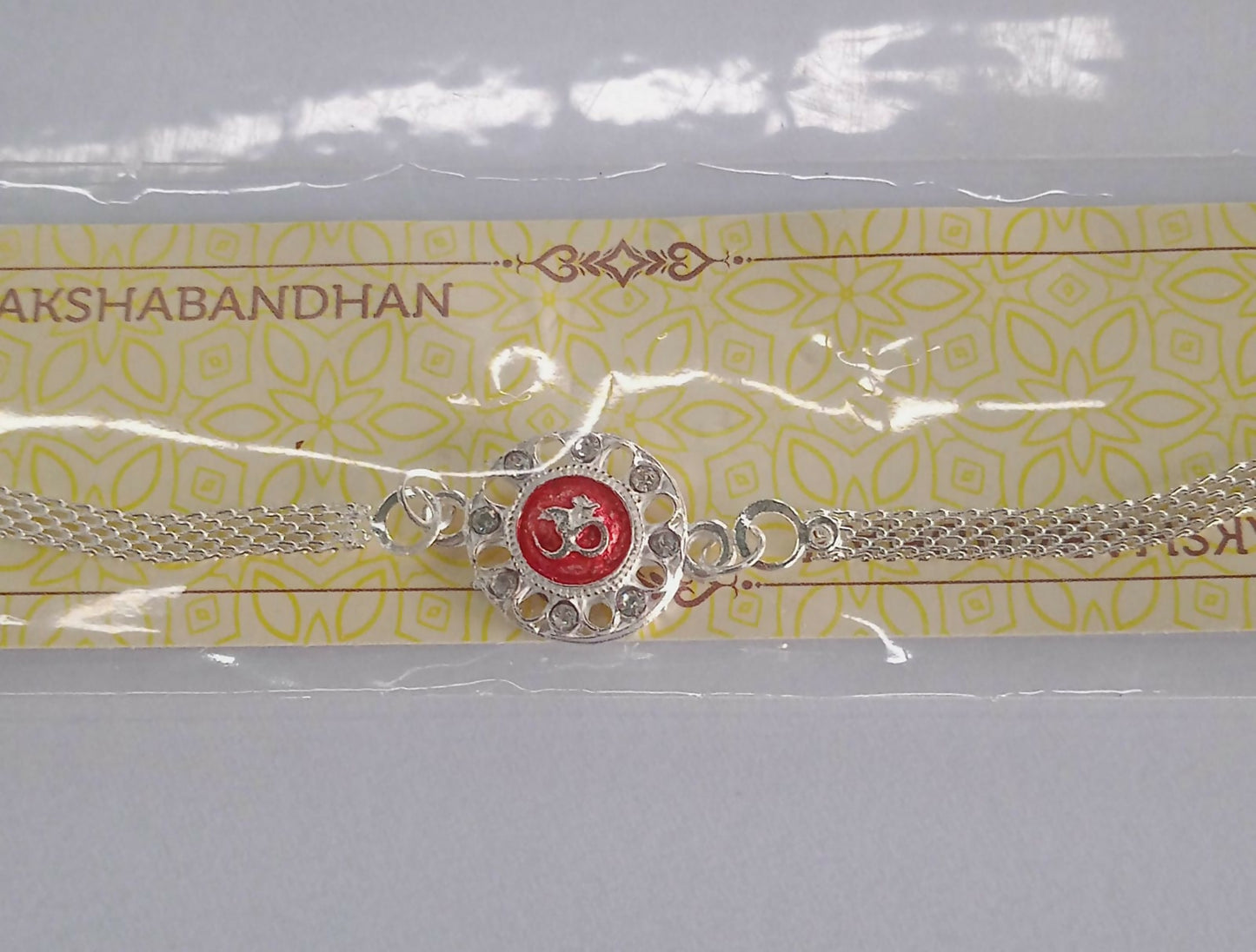 Silver Plated Om Rakhi With Red Enamel And Chain Thread Design